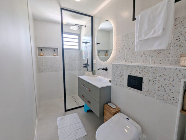Salle de bain avec lavabo et douche moderne à la villa Nateina Home au Gosier
