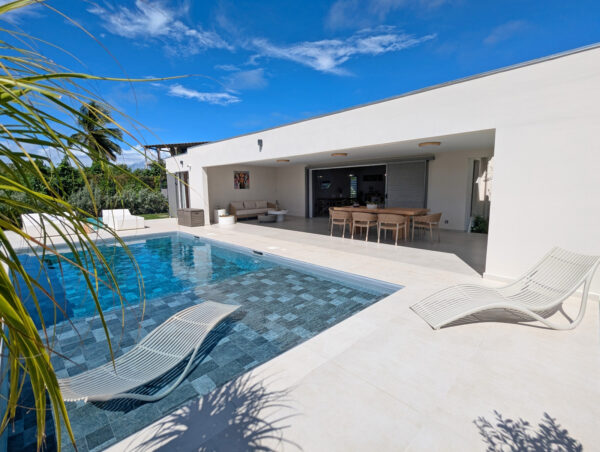 Terrasse avec piscine et transats de la villa Nateina Home au Gosier – espace extérieur relaxant