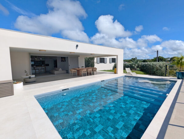 Piscine et terrasse avec transats à la villa Nateina Home au Gosier